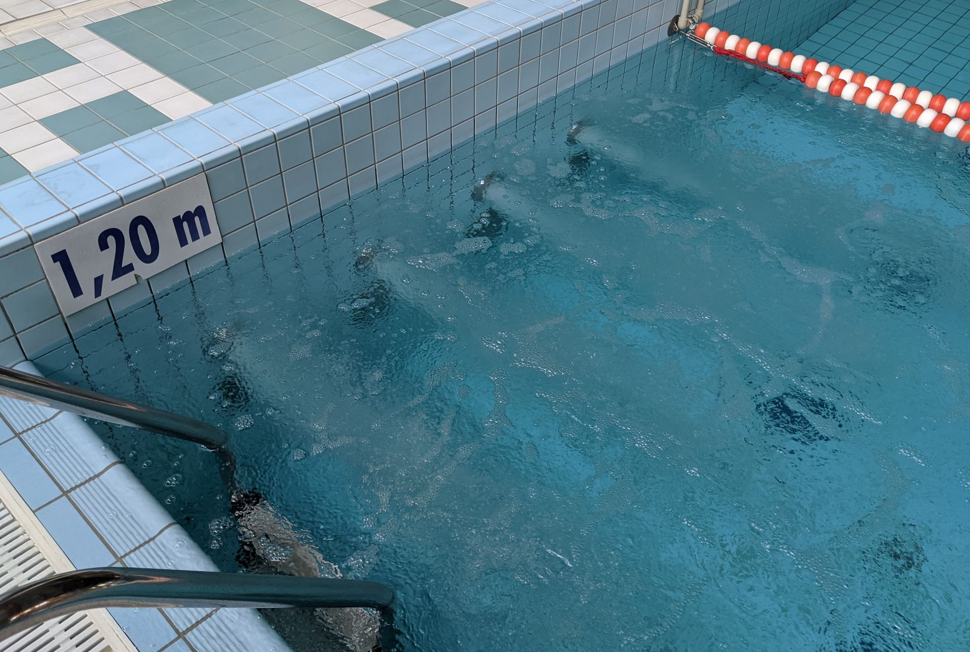 Masaż ścienny czterodyszowy umiejscowiony w basenie rekreacyjnym na ścianie basenu pod wodą, widoczne cztery strumienie wody wydobywające się z dysz.